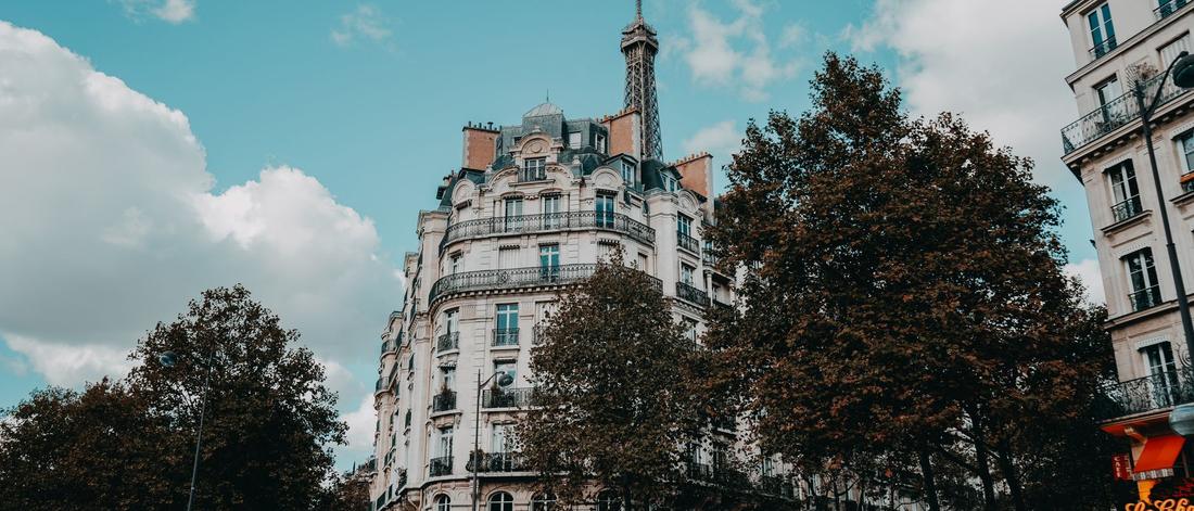 Charming urban street scene in Paris with classic architecture and the Eiffel Tower.