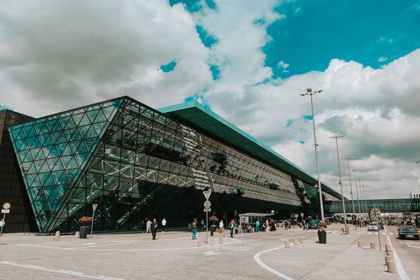 Contemporary airport terminal featuring striking glass facade under a cloudy sky.