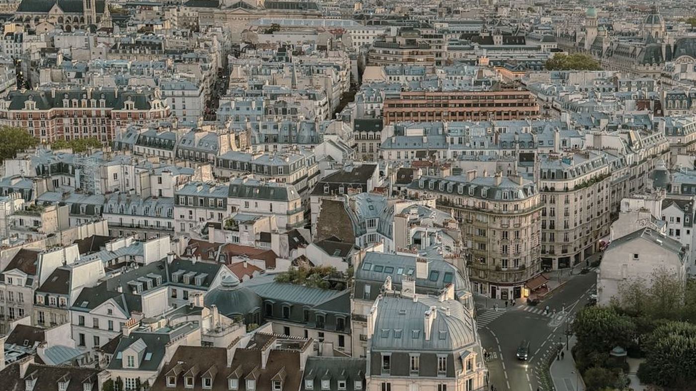 Aerial view of Paris rooftops at sunset, featuring the Pantheon.
