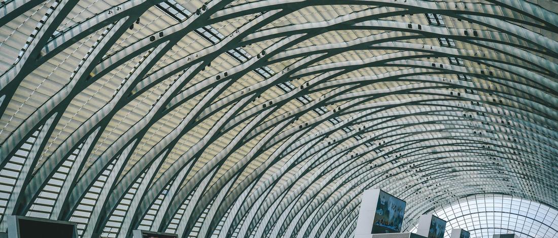 Spacious indoor view of a modern airport terminal with futuristic, arched architecture.