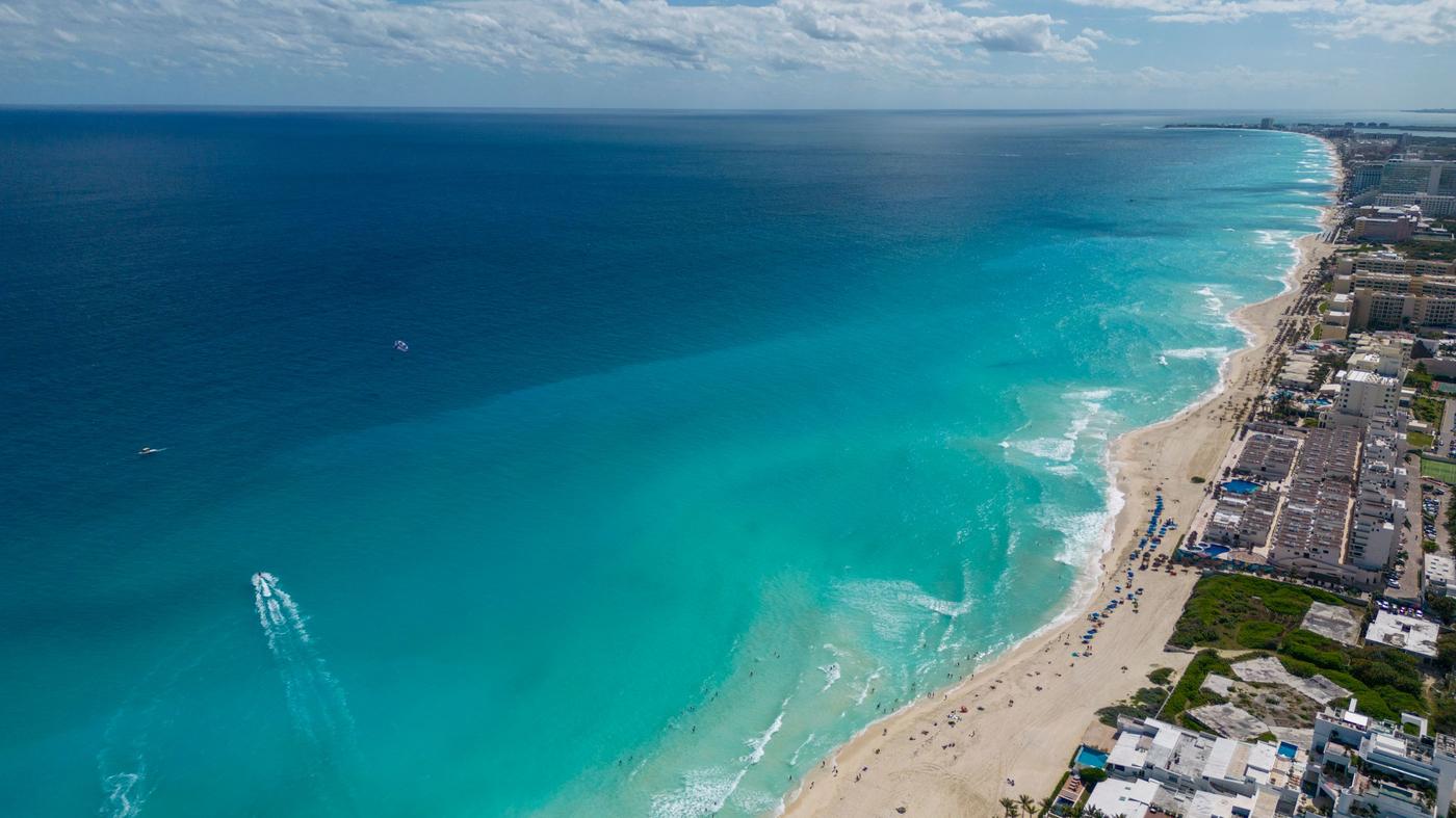 A breathtaking aerial view of Cancun's turquoise waters and sandy beaches lined with hotels.