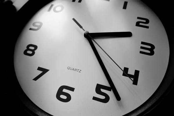 A detailed black and white close-up of a quartz clock emphasizing the numbers and time precision.