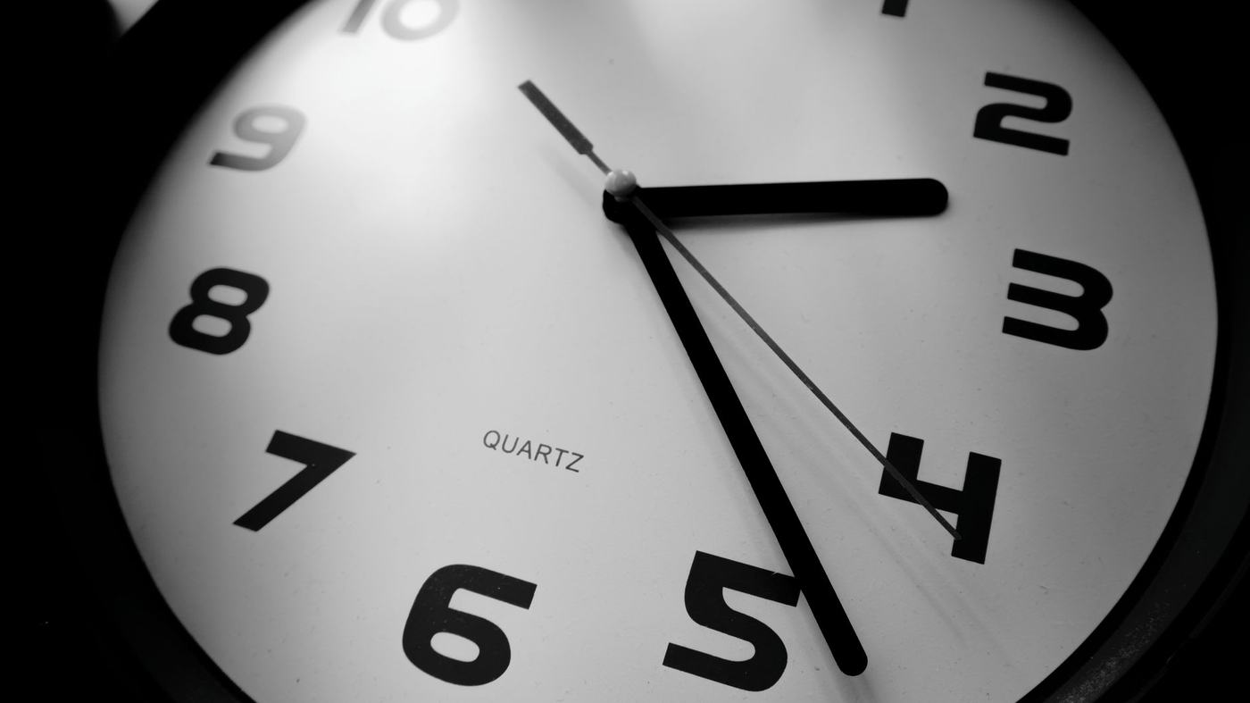 A detailed black and white close-up of a quartz clock emphasizing the numbers and time precision.