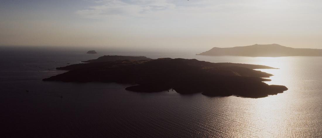 A stunning aerial view of the Greek islands in Fira at sunset. Serene seascape and sky.